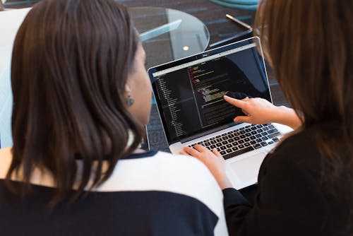 Gratis Dos Mujeres Mirando El CÃ³digo En La Computadora PortÃ¡til Foto de stock