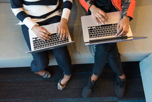 Free Two People Holding Macbook Pro Stock Photo