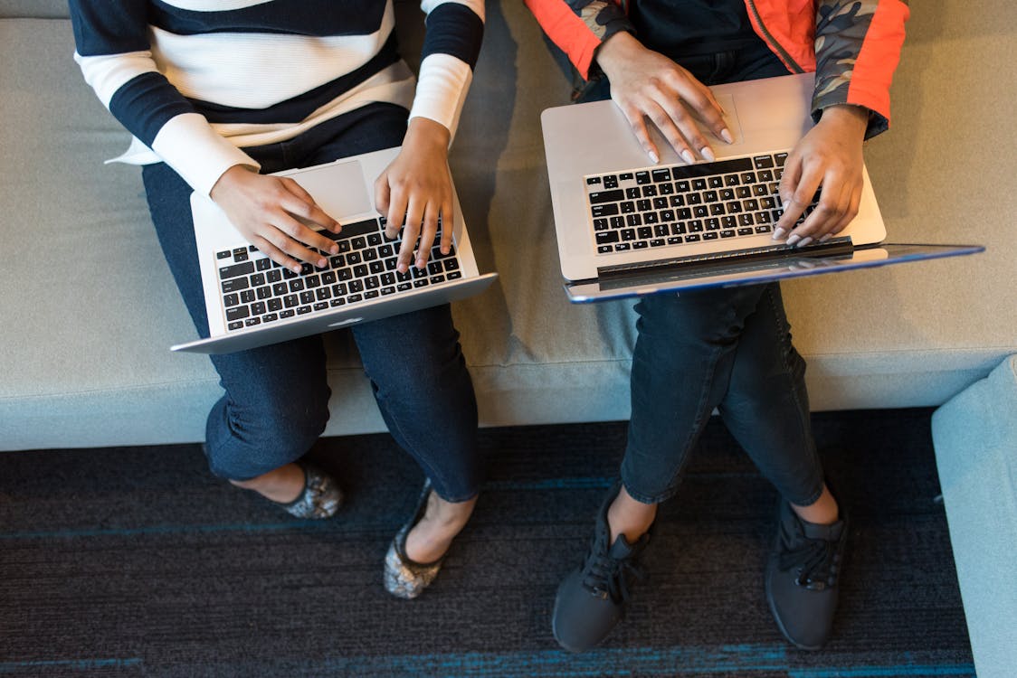 Free Two People Holding Macbook Pro Stock Photo