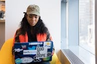 在现代办公环境中，年轻女性正紧张地使用笔记本电脑工作