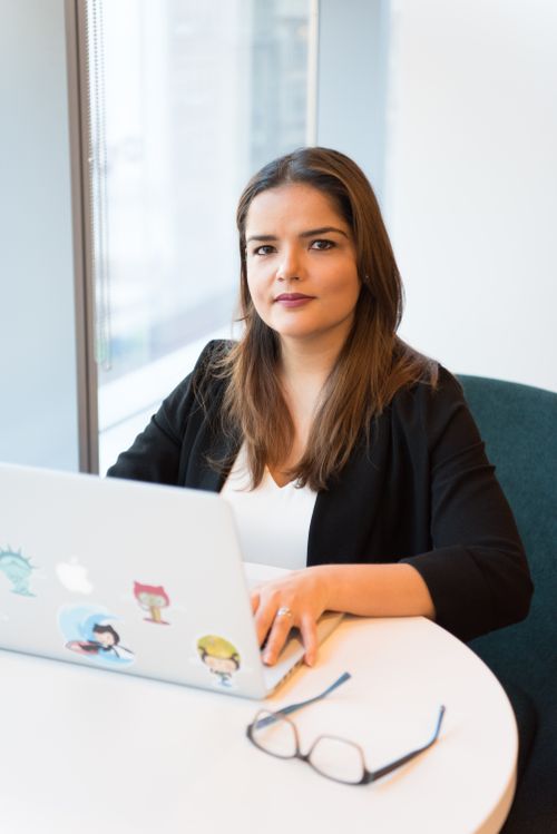 Free Confident businesswoman using laptop for remote work in a stylish office setting. Stock Photo