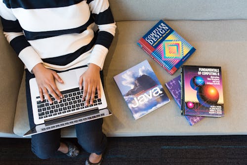 Personne Utilisant Macbook Pro Sur Les Genoux De La Personne