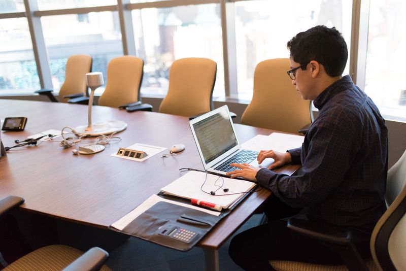 A colleague reviewing plans on a laptop in a bright open office. Photo by Christina Morillo on Pexels.