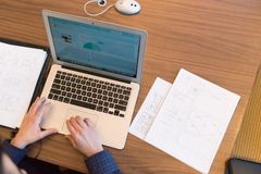 Participant working through a task on a laptop beside printed screens, photo by Christina Morillo on Pexels