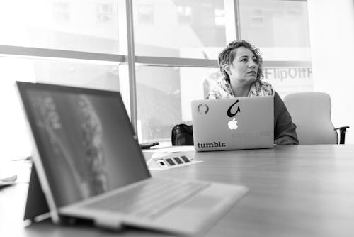 Grayscale Photography of Laptop Computer Near Woman Sitting on Chair