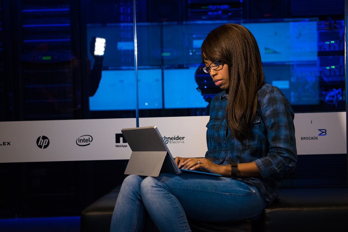 Photo of Woman in Blue Jeans Using Laptop