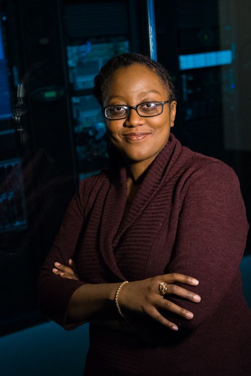 Free Portrait of a confident woman in a tech setting with crossed arms in a server room. Stock Photo