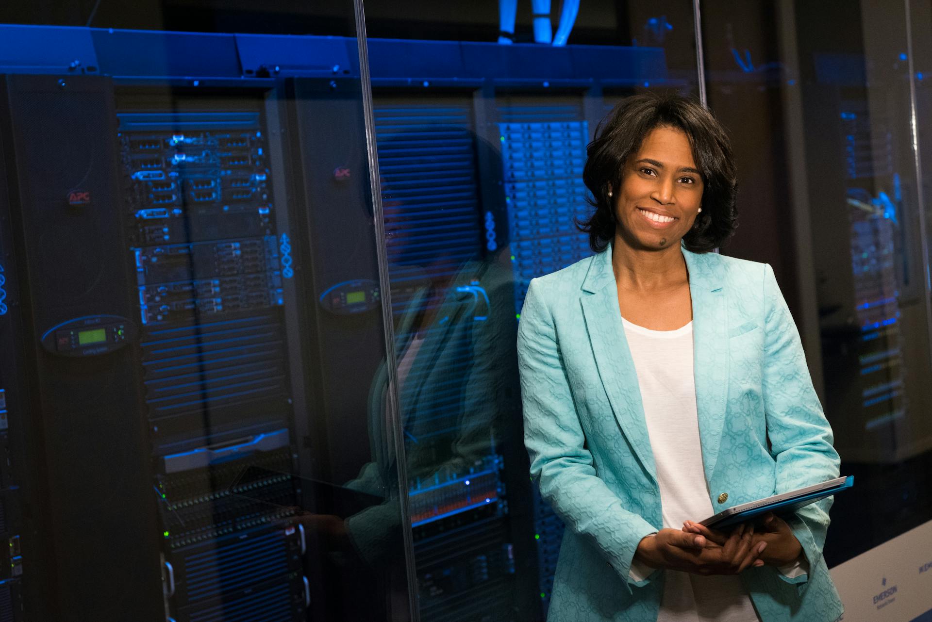 Smiling woman in data center showcasing technology expertise.