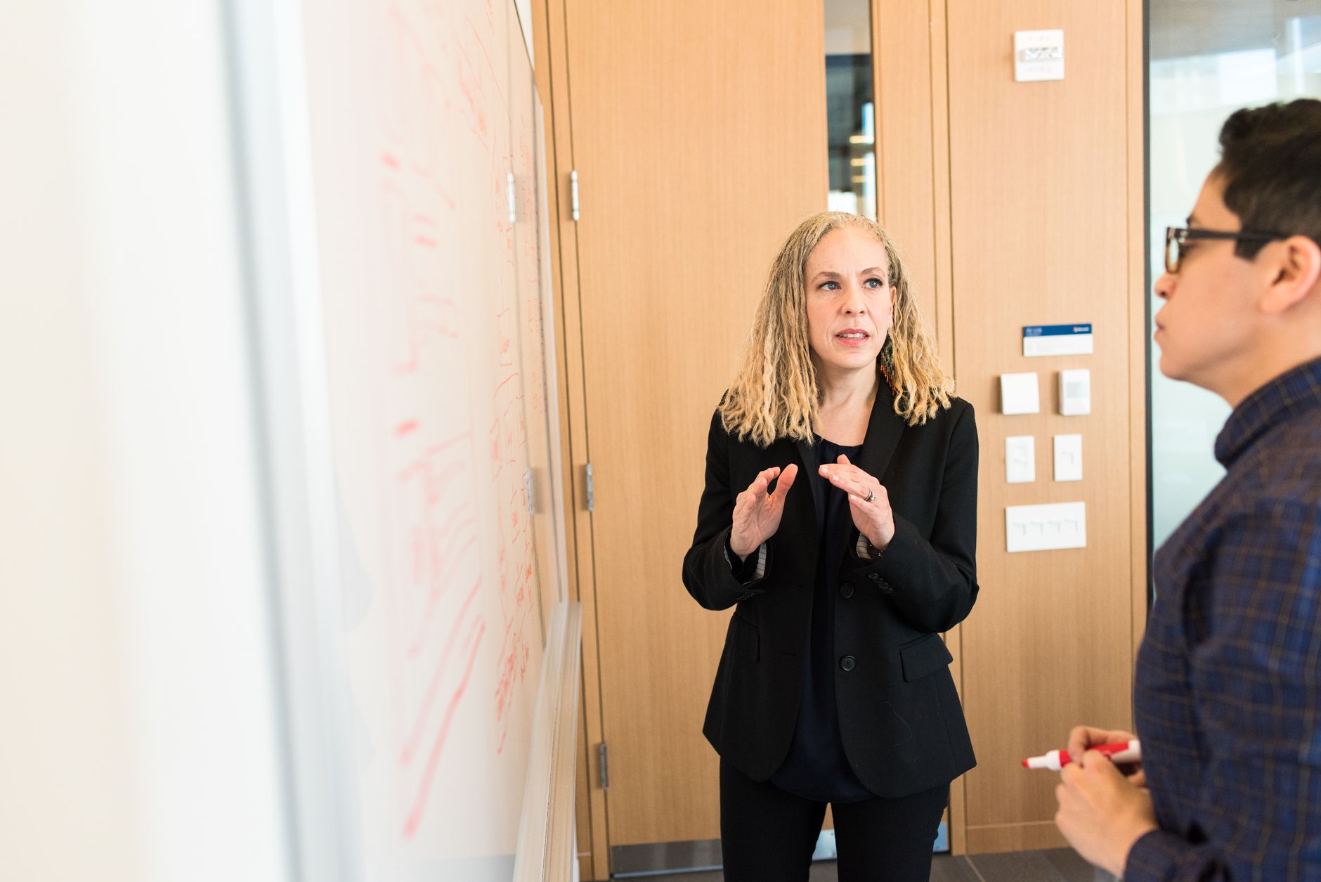 Two professionals engaged in a business discussion in a well-lit modern office space.