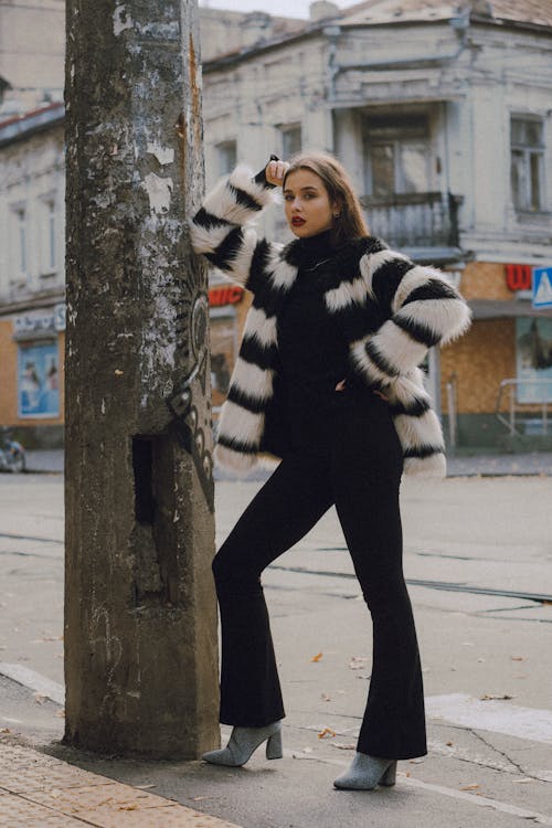 Free Woman in Fur Coat Leaning on a Post Stock Photo