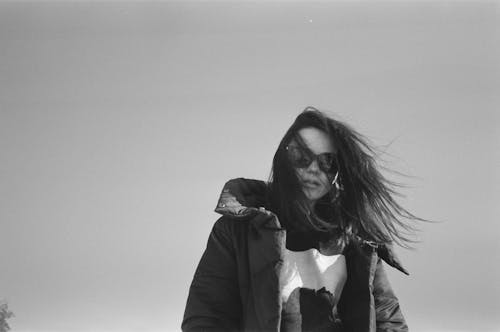 Black and White Photo of a Woman with Tousled Hair Wearing Winter Jacket