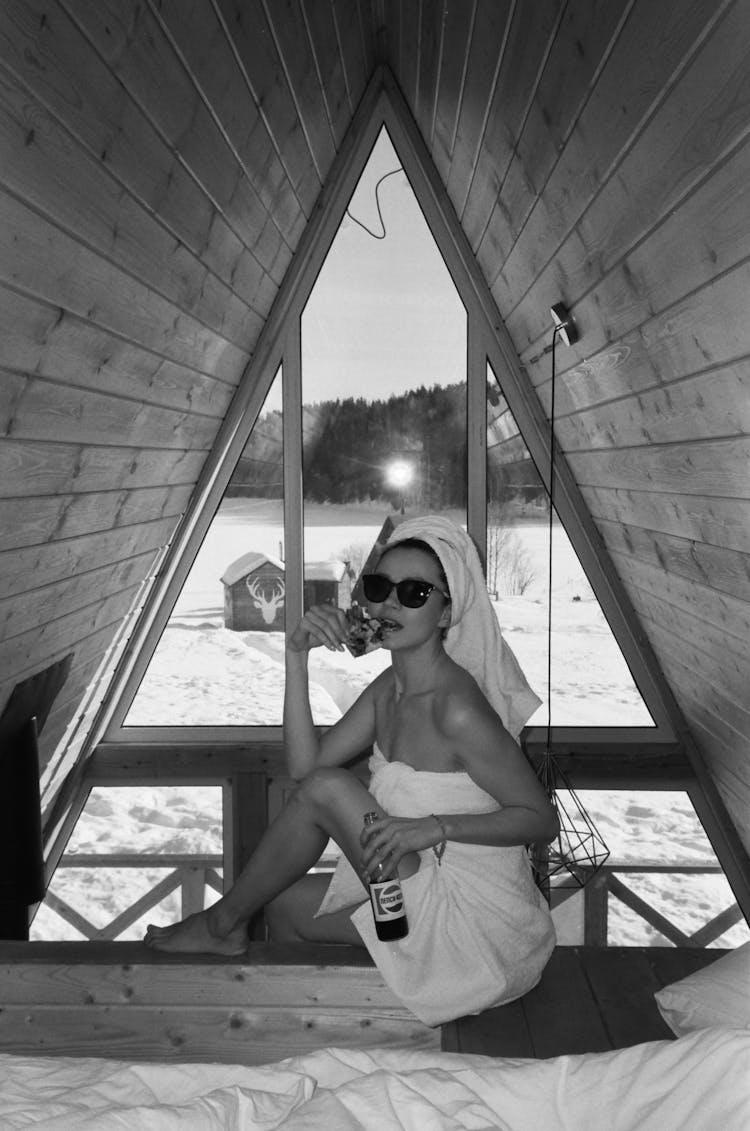 Woman Wrapped In A Towel Sitting Under A Shade On The Beach 