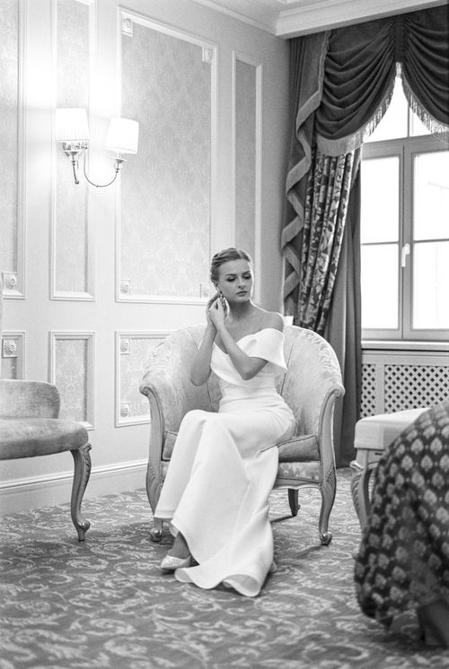 Free A beautiful bride in a white gown prepares for her wedding in an elegant hotel room. Stock Photo