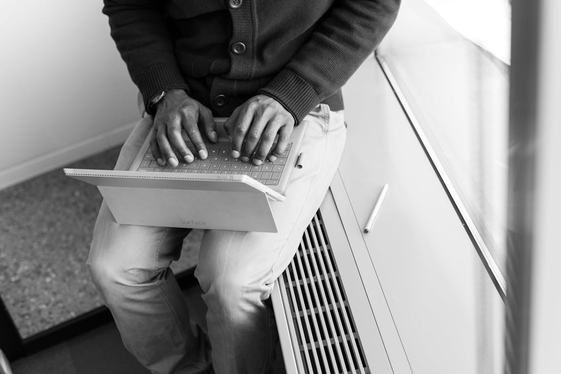 Greyscale Photo of Man Using Laptop Computer