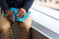 在明亮的办公室窗前，一个专注的男人拿着平板电脑，准备工作