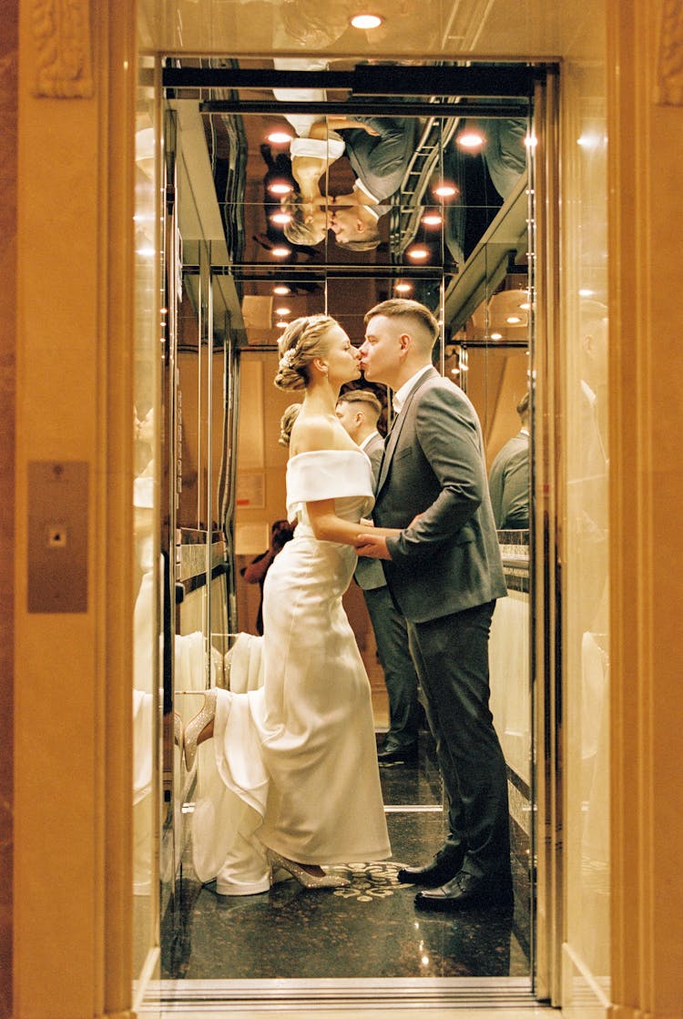 Newlyweds Kissing In An Elevator With Mirrors