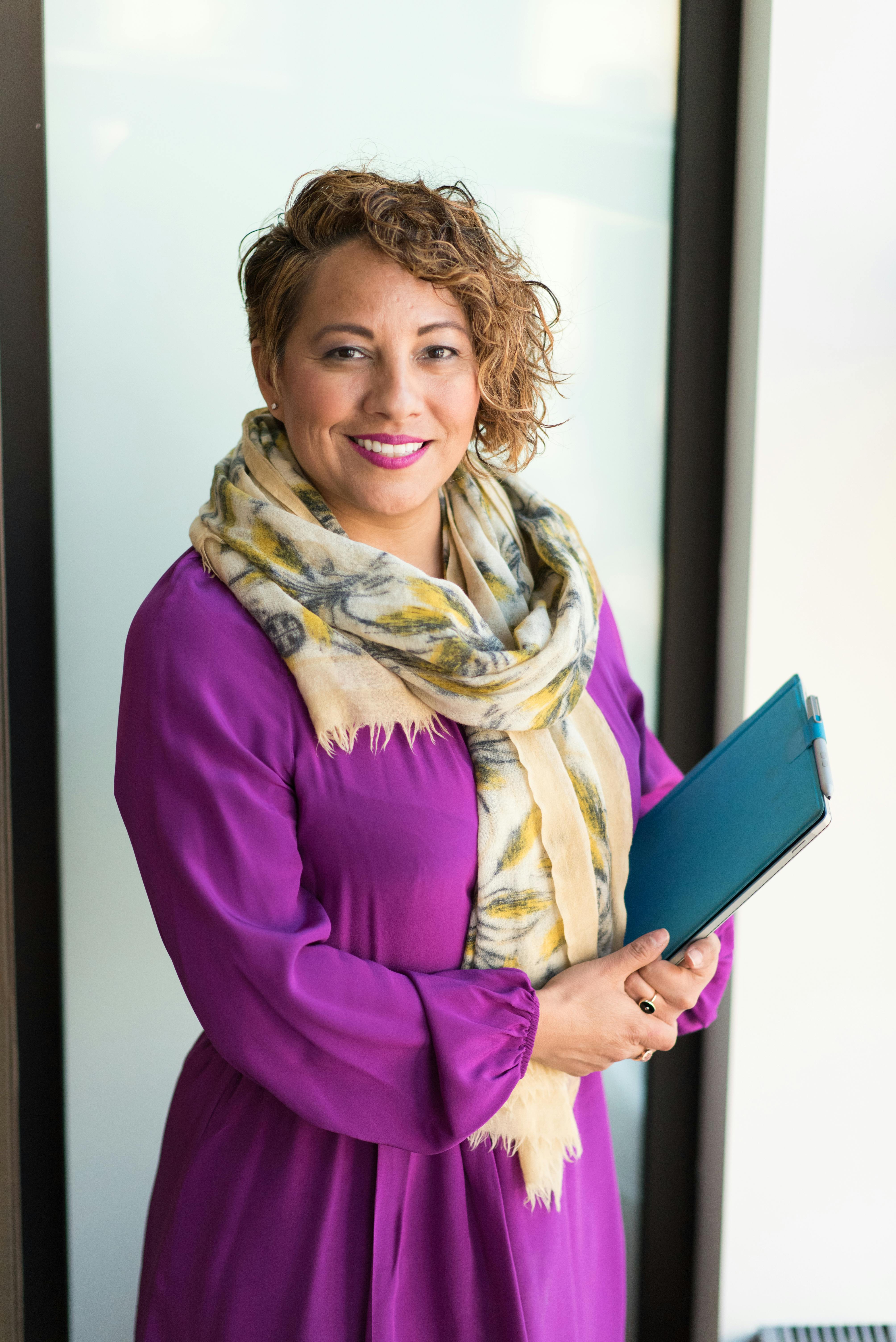 Woman holding a teal book. | Photo: Pexels