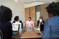 会议室里，多元化的成年人团队正在合作，桌上摆着笔记本电脑和文件