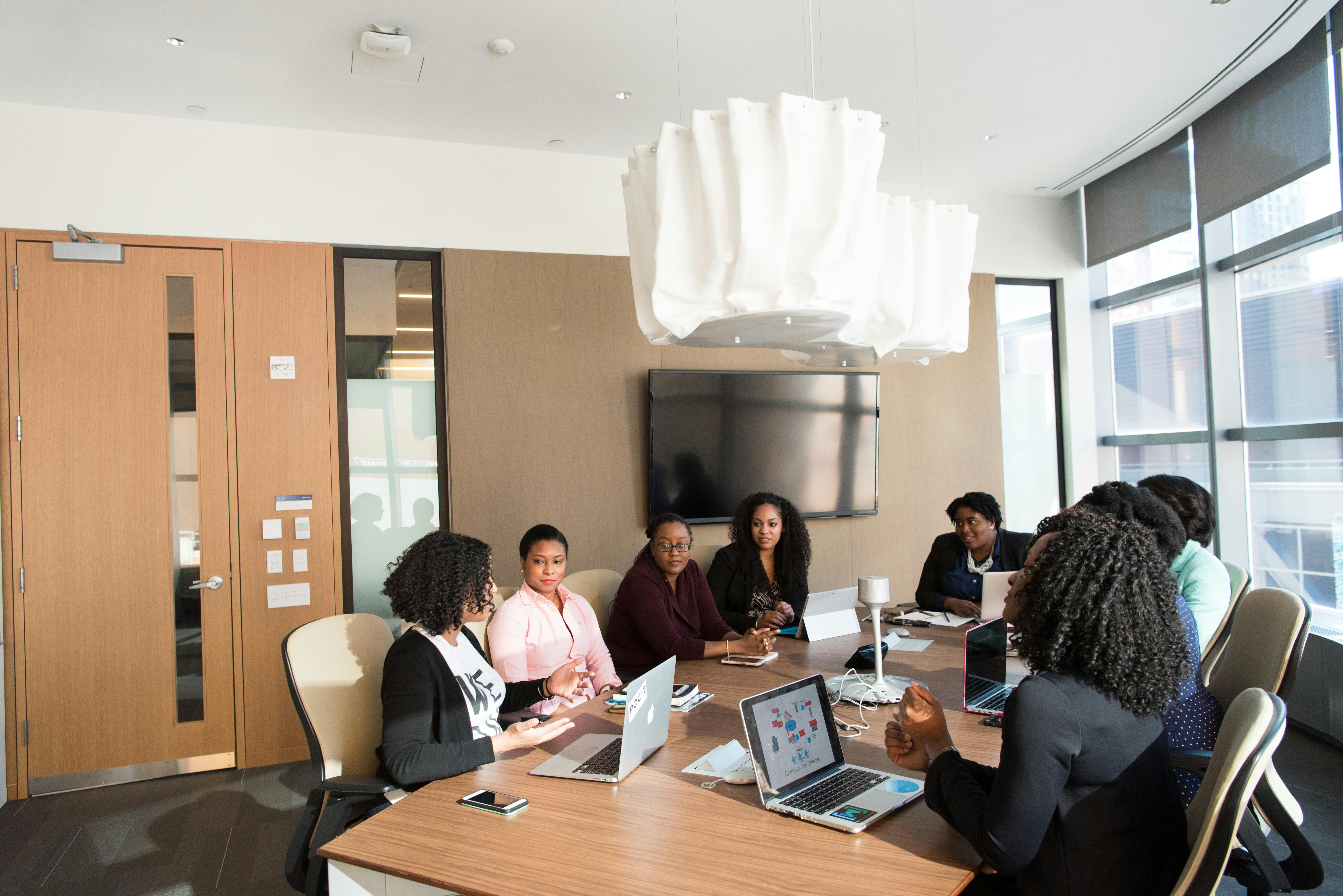 People sitting around a table inside the room | Photo: Pexels