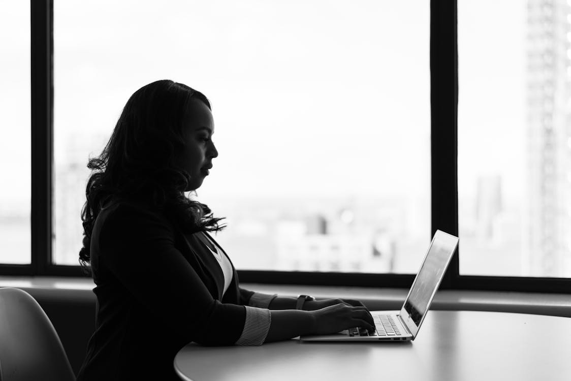 Free Grayscale Photography of Woman Using Laptop Stock Photo