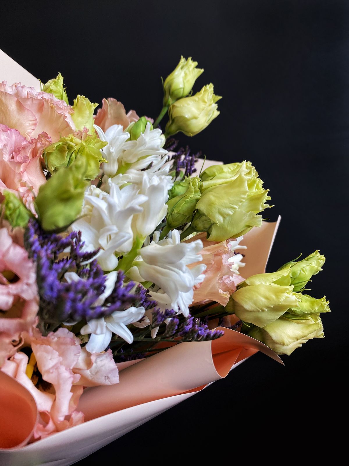 Delivered mixed flower bouquet in close-up against a dark background