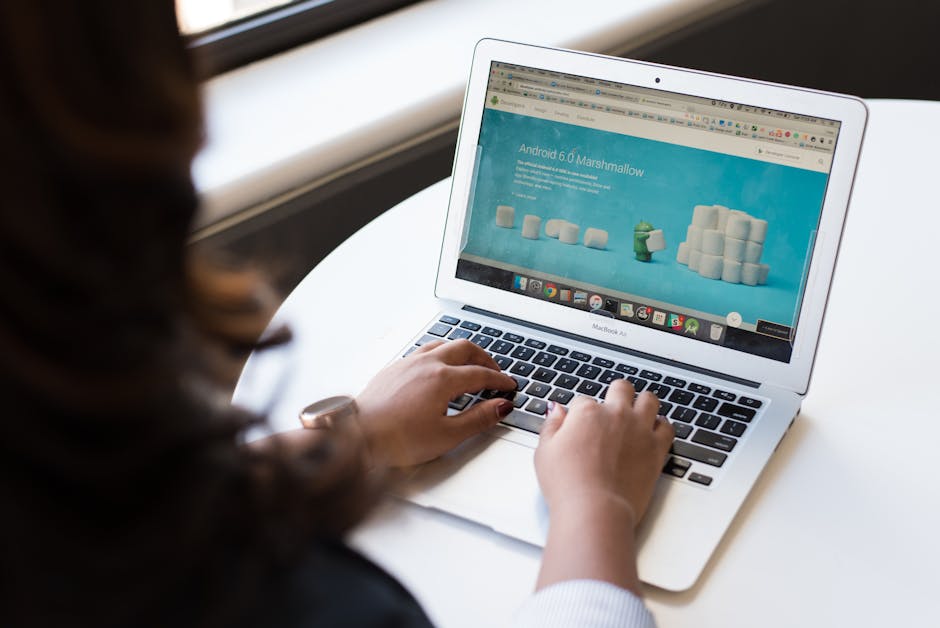 Woman Sitting Near Table Using Macbook