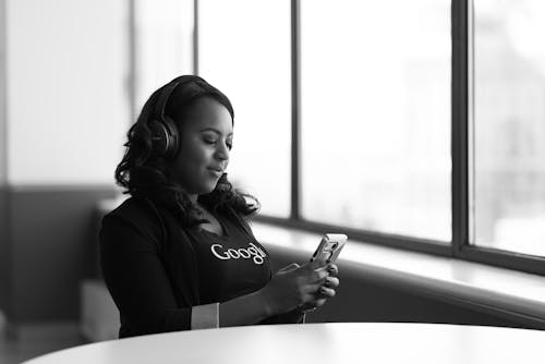 Фотография женщины, держащей смартфон в оттенках серого