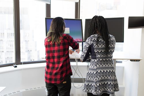 Two Women Standing in Front of Television