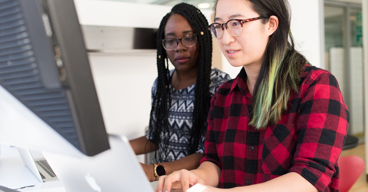 Woman Wearing Red and Black Checkered Blouse Using Macbook