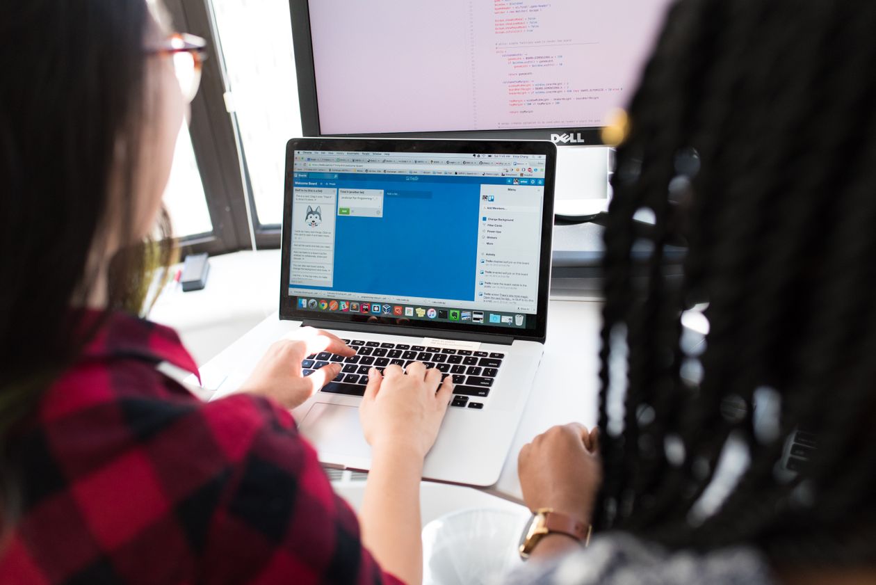 Two women working together on a laptop