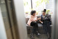 在现代办公环境中，两名妇女正讨论笔记本电脑上的项目工作