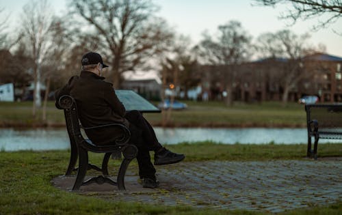 A Man Sitting on a Park Bench Near a Marker