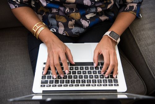 Free Close-up of a woman's hands typing on a laptop with an Apple Watch and bracelets. Stock Photo