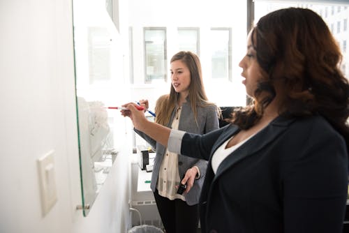 Free Two Women Writing on the White Board Stock Photo