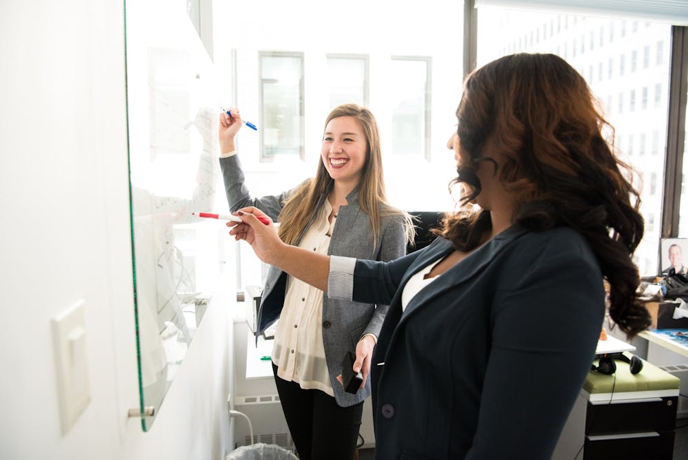 Businesswoman brainstorming company names with sticky notes.