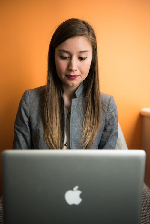 Woman in Gray Suit Coat Using Silver Apple Macbook