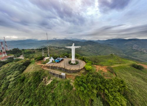 Free Aerial view of the Christ the Redeemer statue overlooking lush green mountains and cloudy skies. Stock Photo