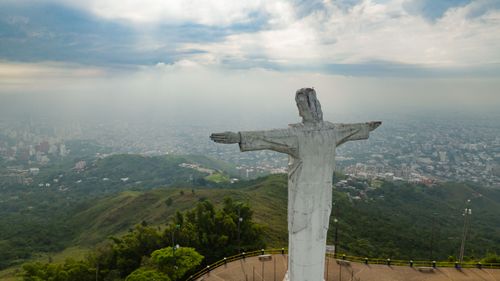 Free Aerial view of the Cristo Rey statue in Cali, Colombia with a cloudy city backdrop. Stock Photo