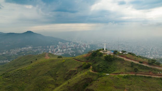 A stunning aerial view of the iconic Cristo Rey statue overlooking Cali, Colombia.