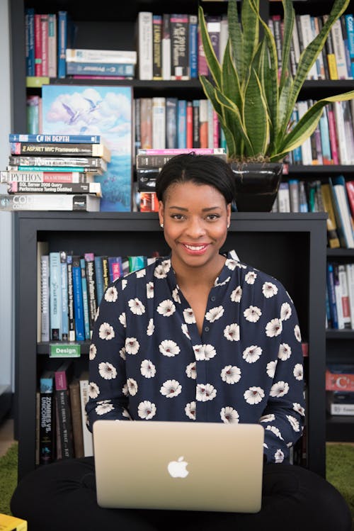 Free Woman in Black Floral Long-sleeved Top Near Book Shelves Stock Photo