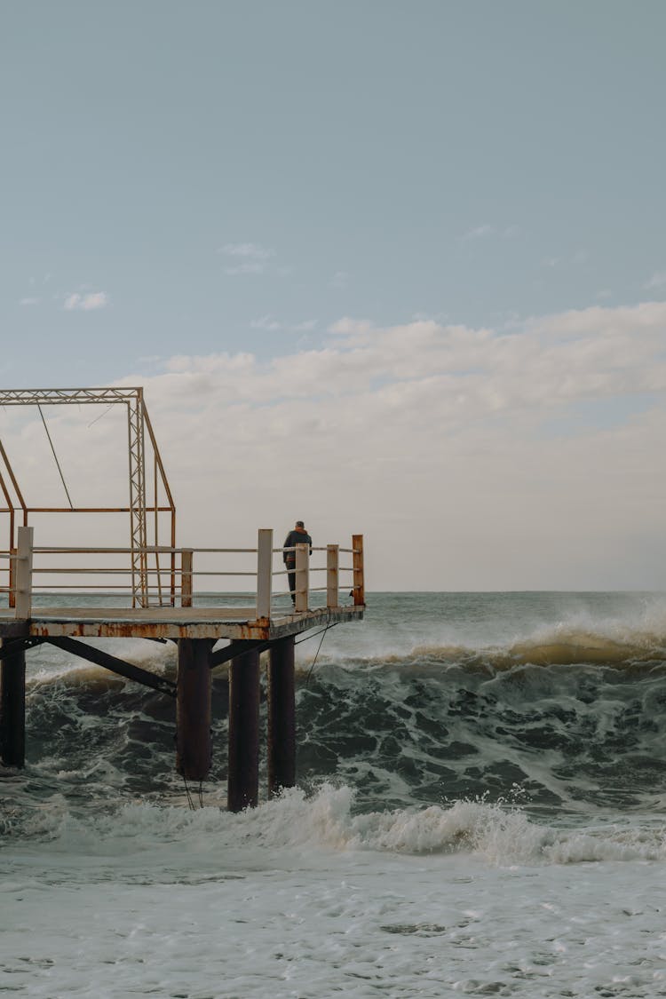 Waves Crashing On A Shore With A Deck