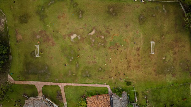 Aerial shot of a soccer practice with players on a grassy field, view from above.