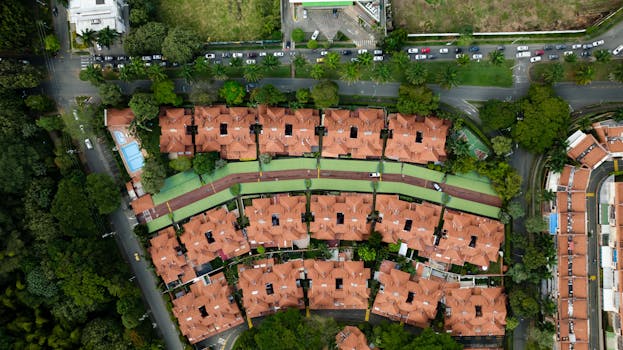 Aerial perspective of urban residential area with lush greenery and clay rooftops.
