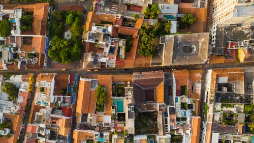 Free A vibrant aerial view of a bustling urban neighborhood with colorful rooftops and lush greenery. Stock Photo
