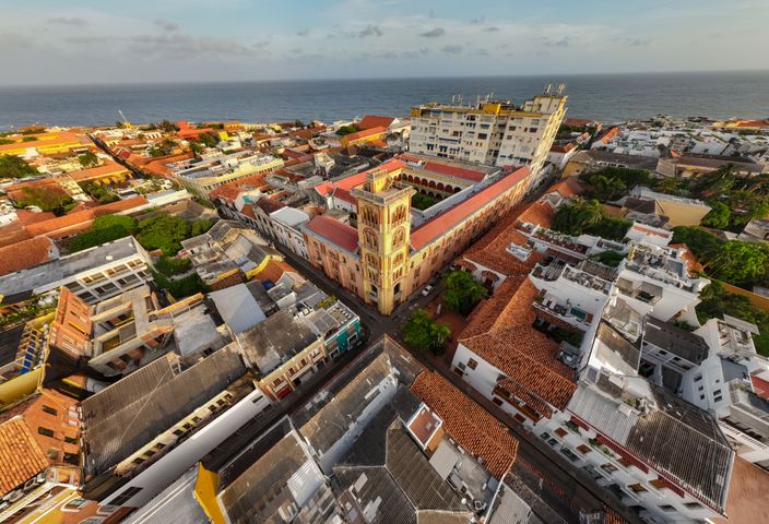 A stunning aerial shot of a coastal town with historic architecture and vibrant rooftops by the sea.