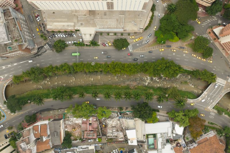 Aerial view showcasing a city's urban layout with roads, greenery, and palm trees.