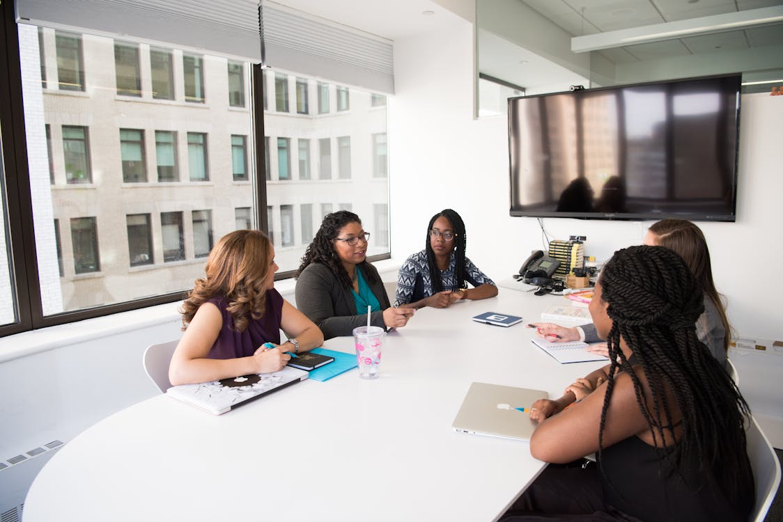 Corporate Housing - Five Women Gathering Inside Office Stock Photo