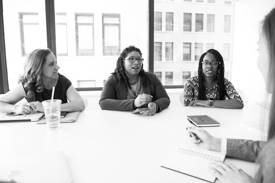 Mujeres profesionales reunidas en un entorno de oficina moderno, enfocándose en la colaboración y el trabajo en equipo.