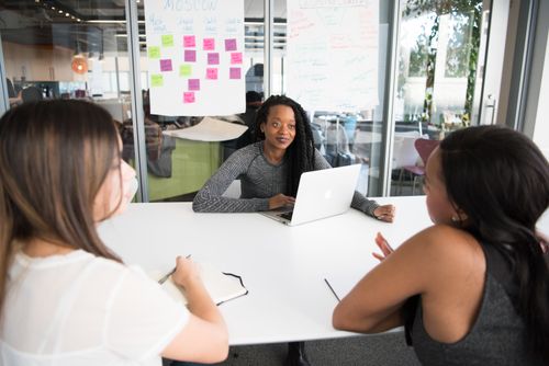 Free A diverse group of women collaborates around a desk in a modern office setting. Stock Photo