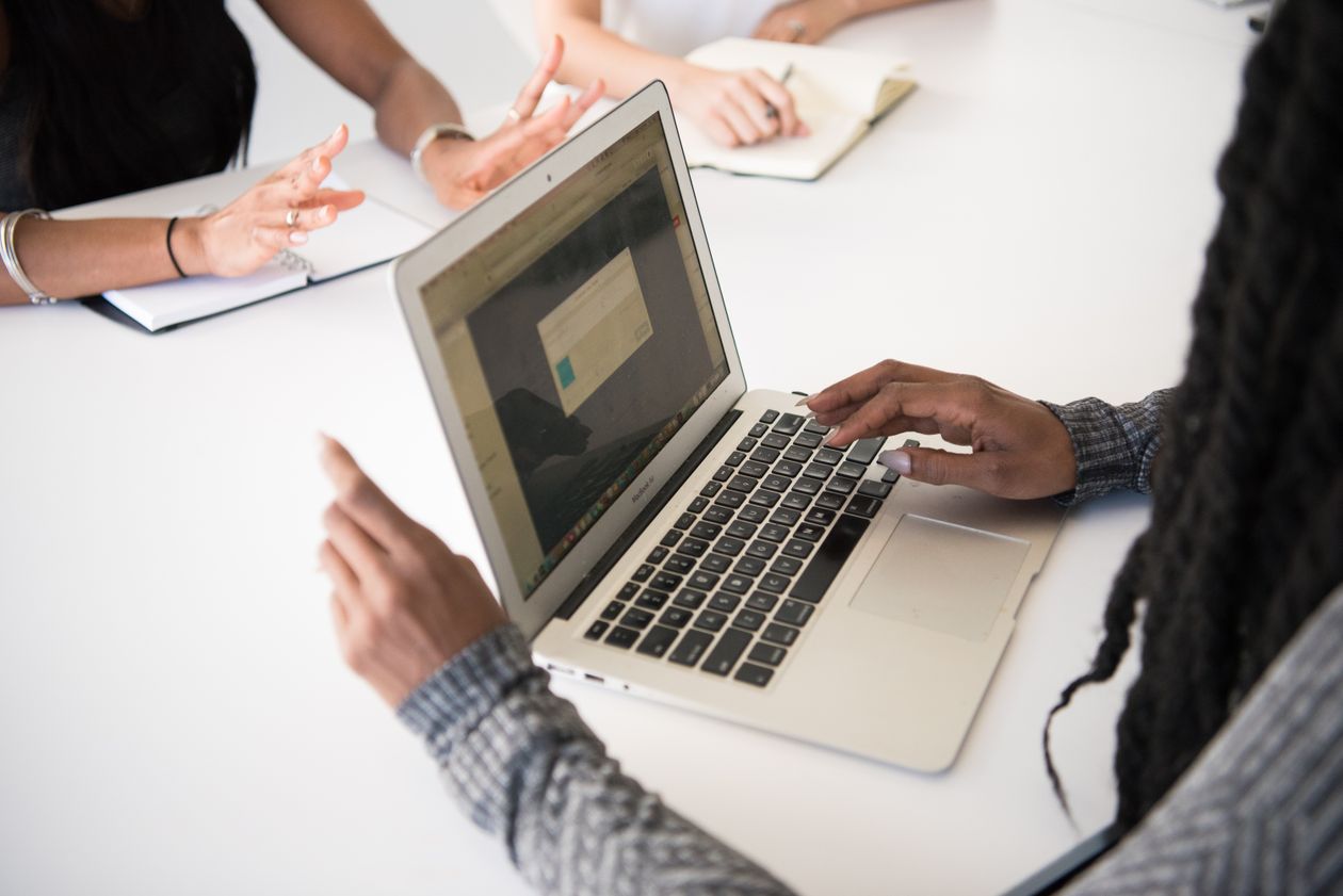 Colleagues working together with a laptop and handwritten notes